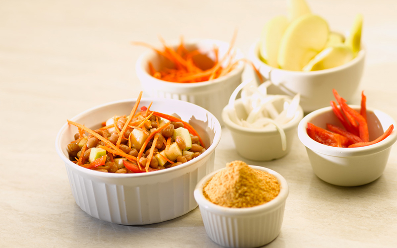 Several small white dishes. A larger one holds the Baked Bean Calcutta and the smaller ones hold ingredients.